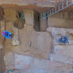 Aerial view of archaeologists pointing out features in brick church