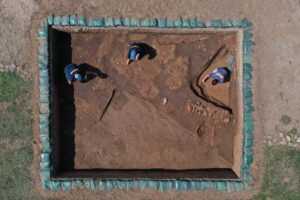 Staff Archaeologists Caitlin Delmas, Gabriel Brown, and Natalie Reid pose for a drone shot at the 1607 Burial Ground.