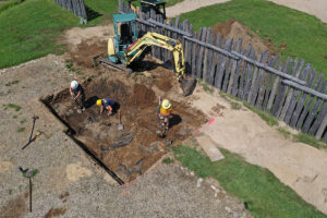 Outside contractor Tim Schmidt helps the archaeologists remove the backfilled soil from the 2000s excavations above the burials.