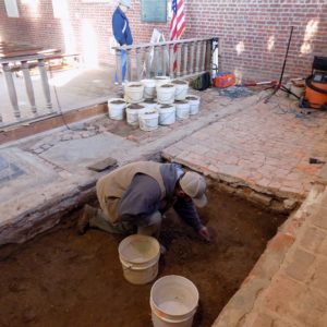 Archaeologist excavating floor inside brick church