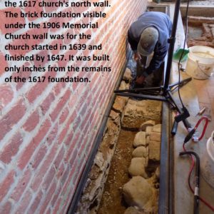 Archaeologist excavates next to brick wall
