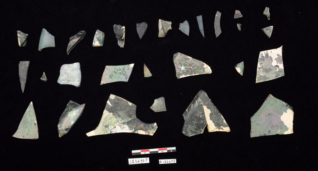 The bottle is in two large fragments with several loose shards. A sample of the 132 shards of glass making up the bottle.