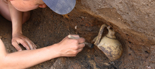 Archaeologist excavating jar