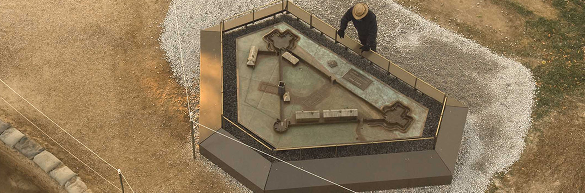 Aerial view of archaeologist looking at a model of James Fort