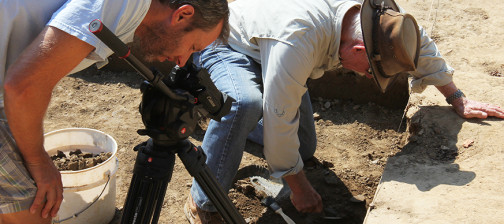 Man films archaeologist excavating