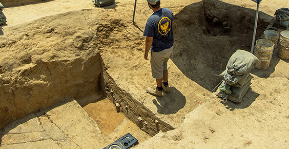 Archaeologist standing on a balk between two excavation units