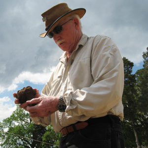 Archaeologist holding a corroded iron artifact