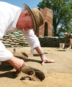 archaeologist brushing off a buried rapier hilt