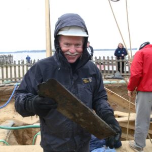 Archaeologist shows a barrel stave to the camera