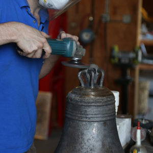 Worker uses tool on crown of cast bell