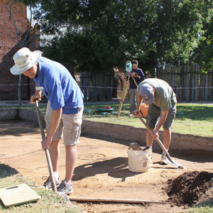 Archaeologists excavating with shovels