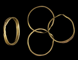 Two views of a gimmel ring, one of three connected hoops and the second of the joined ring 