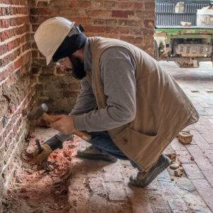 Archaeologist excavating in a brick church tower