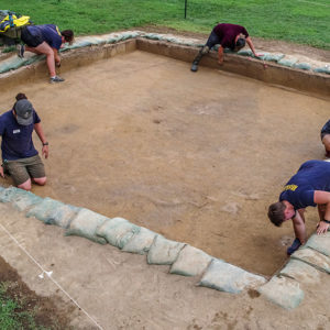 Archaeologists at work in one of the squares containing the 17th-century ditch (darker stain in the center of the square).