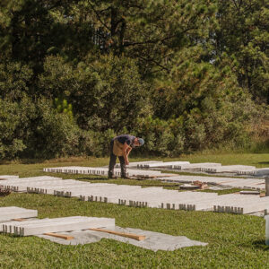 Archaeological Field Technician Hannah Barch and Staff Archaeologist Gabriel Brown painting boards that will comprise the two burial structures used this fall.