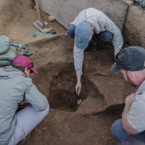 Senior Staff Archaeologist Mary Anna Hartley, Staff Archaeologist Natalie Reid and Director of Archaeology Sean Romo discuss a large posthole feature they found during the 1607 Burial Ground excavations.