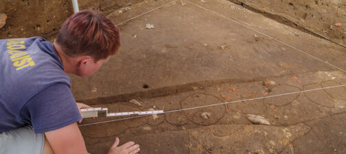 Staff Archaeologist Caitlin Delmas takes measurements of the postholes in a palisade running through the 1607 Burial Ground.