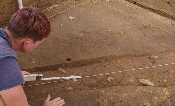 Staff Archaeologist Caitlin Delmas takes measurements of the postholes in a palisade running through the 1607 Burial Ground.