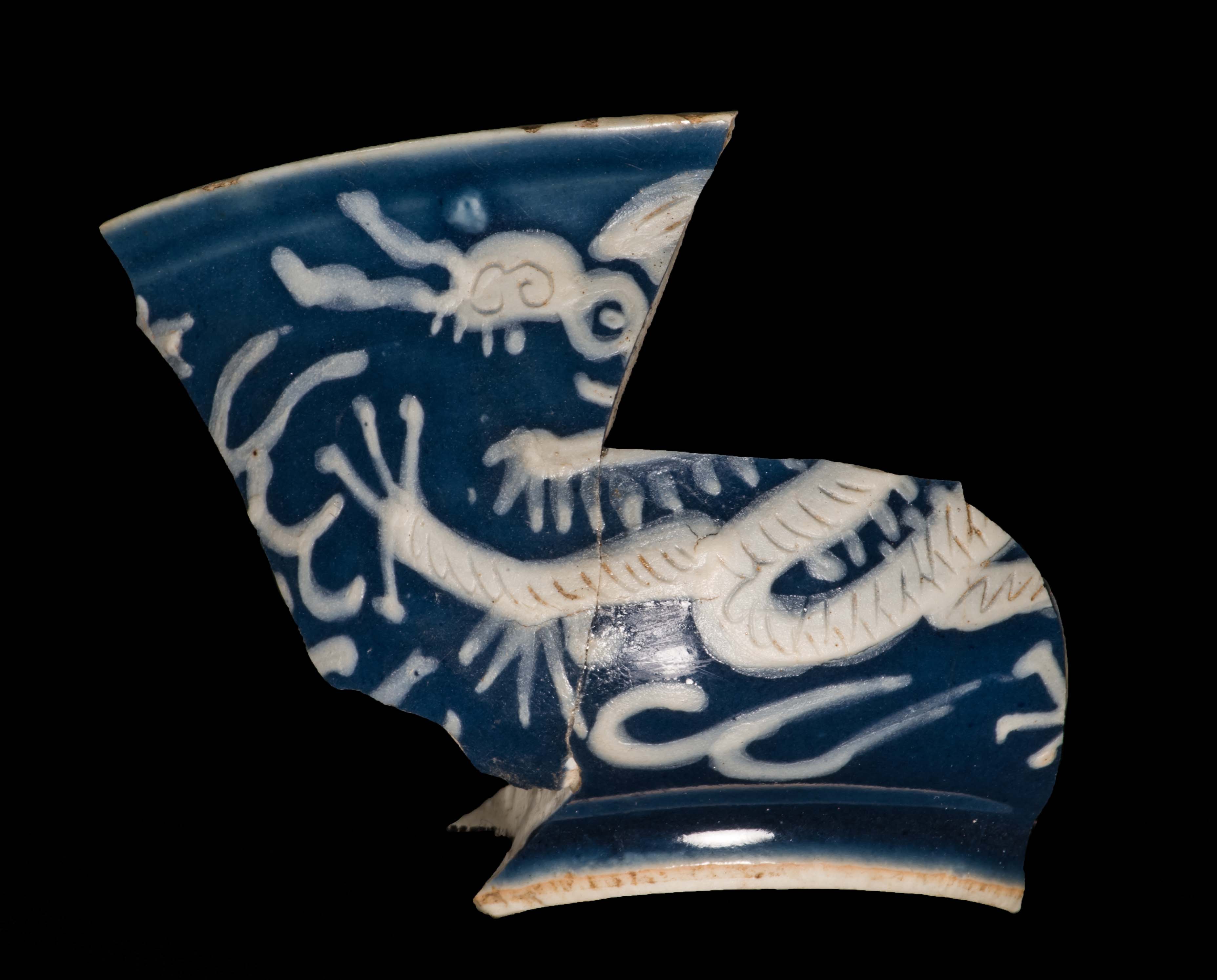 part of a blue bowl with white slip decoration