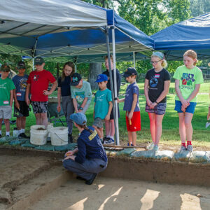 Staff Archaeologist Natalie Reid, manager of the Kids Camp, gives the kids an overview of the excavations at the cellar site.