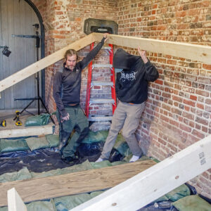 Archaeologists Gabriel Brown and Eli Clem help to build a new floor for the Church Tower to allow visitors back inside.