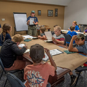 Archaeological Field Technician Eleanor Robb instructs the campers on archaeological illustration.