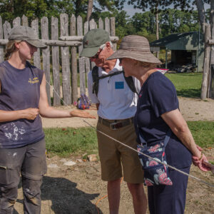 Archaeological Field Technician Katie Griffith shares an artifact found in the 1607 Burial Ground with some visitors.