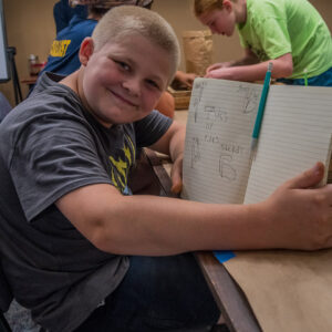 A camper shares his illustrations of artifact types found while sorting.