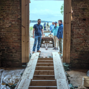 Archaeologists standing in church doorway with in-progress floor ramp