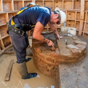 Archaeological Field Technician Gabriel Brown slowly scrapes away at the fill inside the Governor's Well.