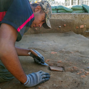 Archaeologist Kalen Anderson excavates a roof tile at the north Church Tower excavations.