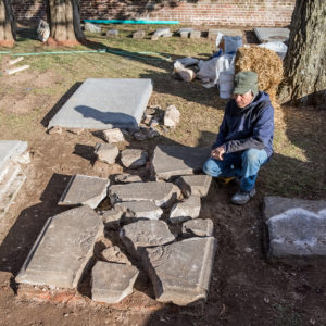 Conservator examines gravestone fragments