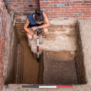 Excavator stands in excavated unit