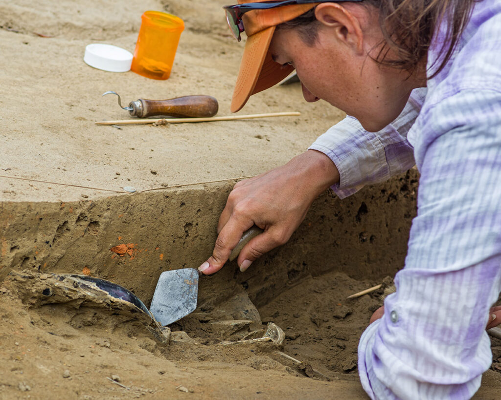 Mary Anna Hartley excavating the bottle from a fort cellar in 2014.