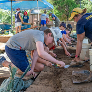 A row of kids trowel at the cellar site.