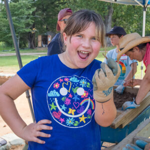 A camper holds a nail she found while screening through soil from the cellar excavations.