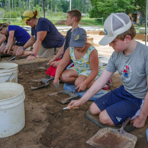 Campers and Archaeological Field Technician Hannah Barch trowel away at the cellar site.