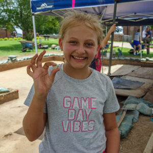 A camper holds a sherd of ceramic she found while screening.