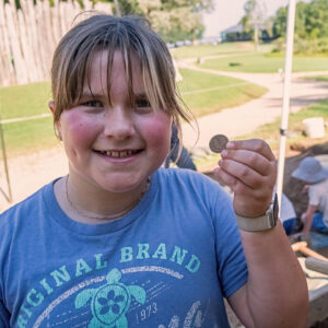 A camper holds the Standing Liberty quarter she found while screening.