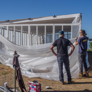 Archaeological Field Technician Eleanor Robb, Staff Archeologist Gabriel Brown, and Senior Staff Archaeologist Anna Shackelford install plastic sheeting on the burial structure at the 1607 Burial Ground.