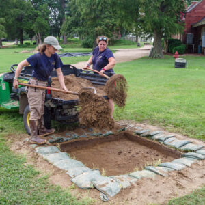 Staff Archaeologist Ren Willis and Archaeological Field Technician Hannah Barch backfill the boring machine test unit near the Dale House.
