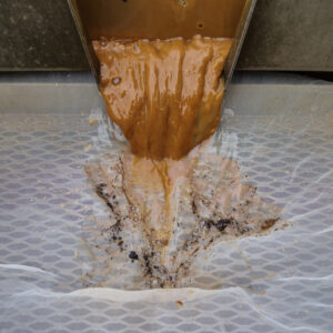Curatorial Assistant Lindsay Bliss uses a half millimeter screen to catch the tiniest artifacts during the flotation of an excavated soil sample.