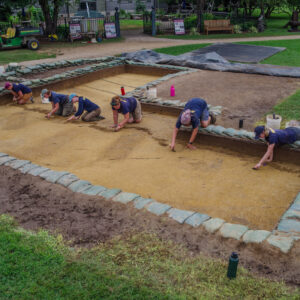 Jamestown Rediscovery archaeologists prepare the excavation site south of the Archaearium for record photography. The dark rectangles are burials.