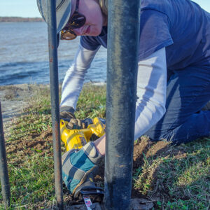Archaeological Field Technician Katie Griffith uses a reciprocating saw to remove a stubborn bolt during the disassembly of the fence surrounding the Statehouse remains.