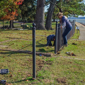Staff Archaeologist Caitlin Delmas and Archaeological Field Technician Katie Griffith disassemble the fence surrounding the Statehouse foundations in order to prepare for ground-penetrating radar (GPR) surveys of the area.