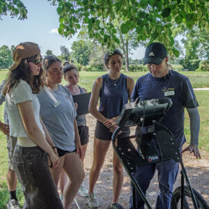 Staff Archaeologist Gabriel Brown gives instruction on using the GPR machine to the field school students.