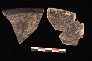 A partial glass dish decorated with gold leaf. Assistant Conservator Jo Hoppe is conserving these pieces prior to inclusion in the glass reference collection.