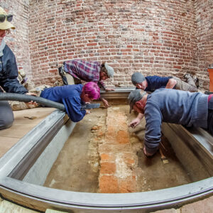 Archaeologists (clockwise from left) Hannah Barch, Caitlin Delmas, Josh Barber, Gabriel Brown and Sean Romo prepare the western foundations of the 1617 church prior to the installation of the glass portal.