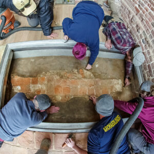 Archaeologists (clockwise from top left) Hannah Barch, Caitlin Delmas, Josh Barber, Ren Willis, Gabriel Brown and Sean Romo prepare the western foundations of the 1617 church prior to the installation of the glass portal.
