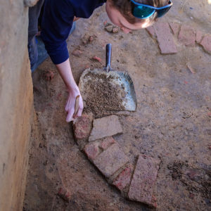 Site Supervisor Anna Shackelford excavates the well.